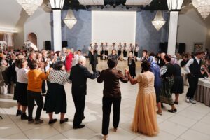 Participanții dansează hora în timpul programului artistic